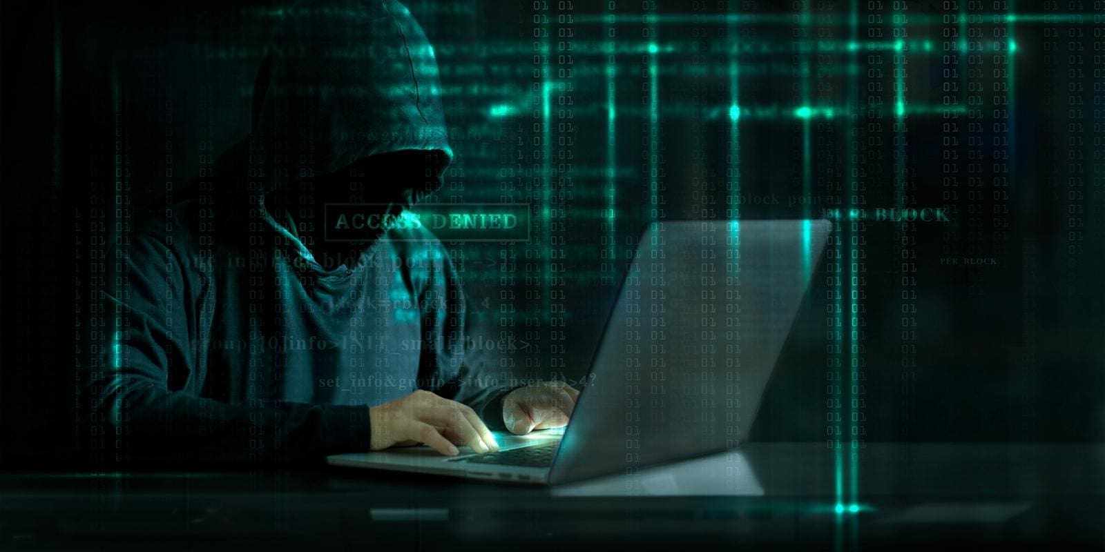 a person wearing a hoodie down using a laptop
