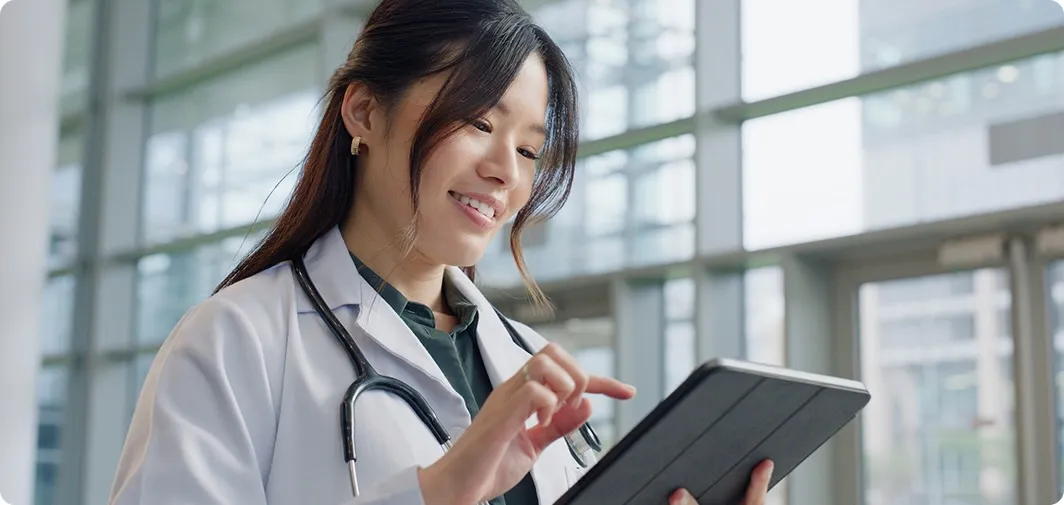 Healthcare professional using a tablet, representing secure healthcare print management, print analytics, and document security with Pharos Insights.