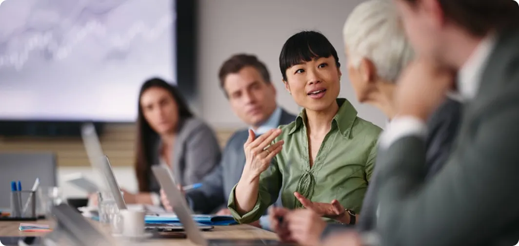 Business professionals collaborating in a meeting, representing print analytics and cost optimization with Pharos Insights for smarter enterprise print management.