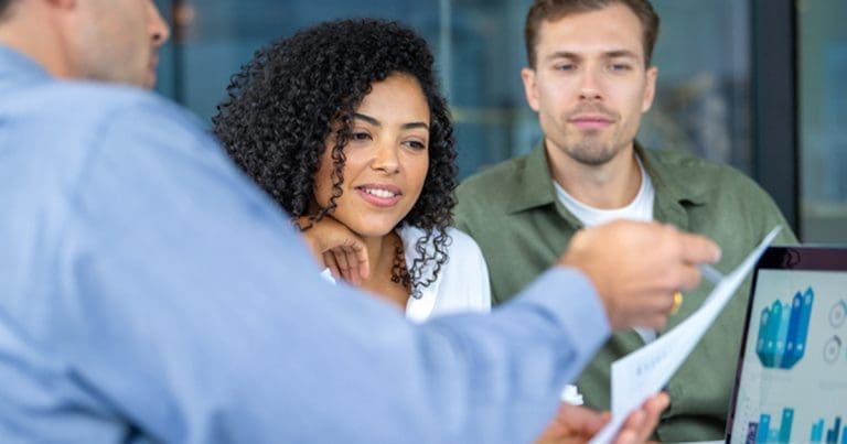employees discussing over a document