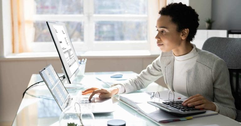 Professional reviewing print audit data and analytics dashboard to identify print costs, usage trends, and optimization opportunities across enterprise print operations