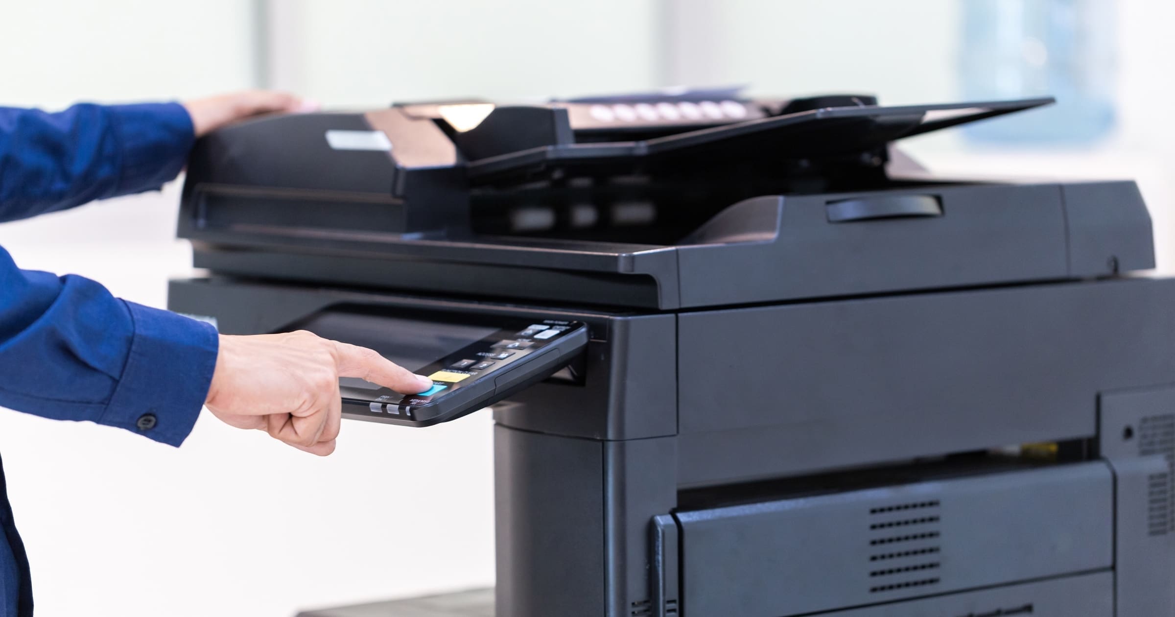 Office worker using a secure multifunction printer, representing Zero Trust print security and protected document workflows.